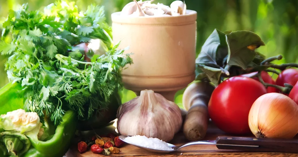 Friss zöldségek és fűszerek konyhai környezetben, a bélflóra és az emésztés egészségét támogató életmód szemléltetésére.