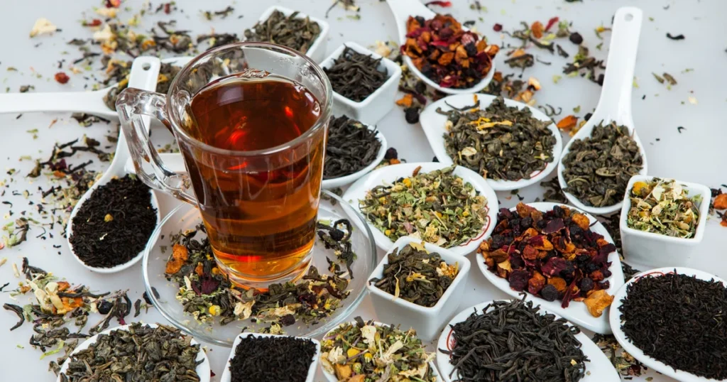 Gyógyteák és teakeverékek egy asztalon, csésze teával, tudatos folyadékbevitel és életmódváltás szemléltetésére.
