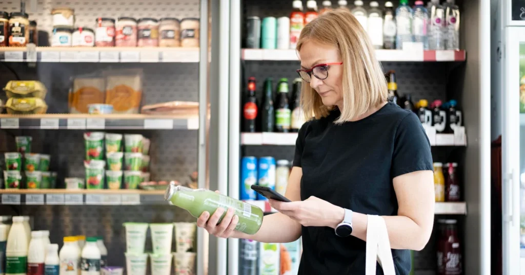 Smoothie címkéjének ellenőrzése életmódváltáskor egy boltban